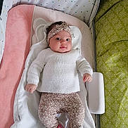 Mitia participe au concours pour gagner de l'argent avec cette photo : baby, infant, headband, knitted_sweater, floral_leggings, pink_sneakers, cushion, blanket, soft_toy, lying_down, indoors, cute, child, person, portrait, cozy, clothing, comfort, smiling, face