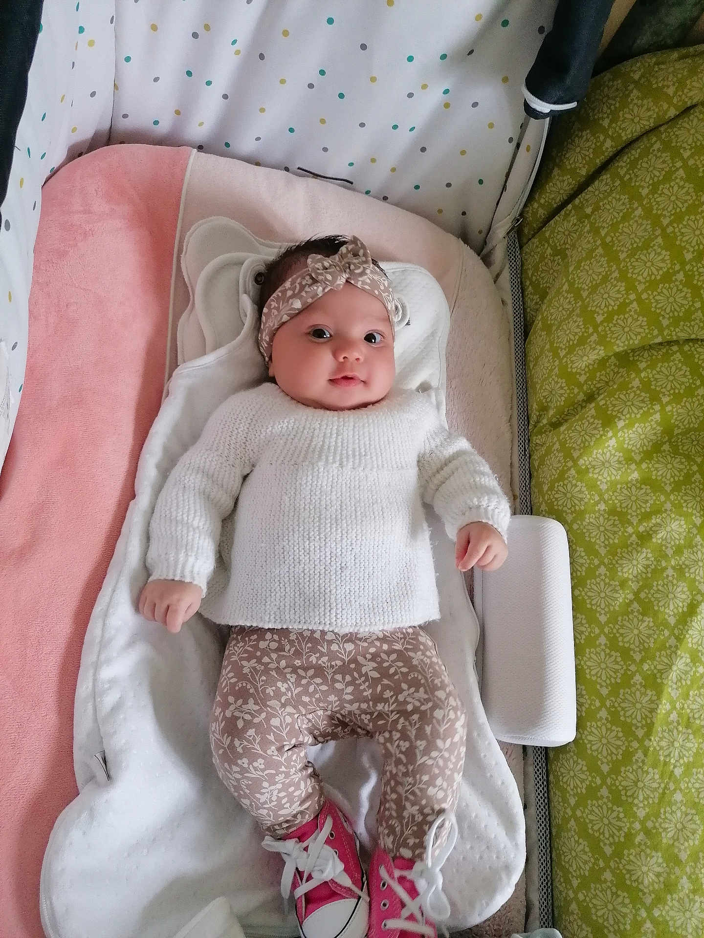 Mitia participe au concours pour gagner de l'argent avec cette photo : baby, infant, headband, knitted_sweater, floral_leggings, pink_sneakers, cushion, blanket, soft_toy, lying_down, indoors, cute, child, person, portrait, cozy, clothing, comfort, smiling, face