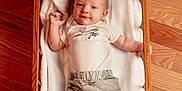Colton joined the competition — help win amazing prizes! baby, cradle, wooden_floor, blanket, infant, clothing, person, cute, indoor, furniture, portrait, smiling, lying_down, child, baby_clothes, soft_texture, wood, relaxing, small, comfortable