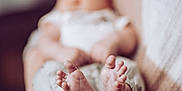 Colton joined the competition — help win amazing prizes! baby, feet, hands, holding, blurred_face, soft_focus, knitted_sweater, warm_colors, cozy, indoor, person, newborn, infant, skin, close_up, parent, comfort, care, small_toes, gentle