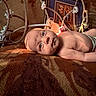 baby, infant, child, portrait, face, eyes, lying_down, blanket, indoor, home, rope, hammock, furniture, framed_picture, warm_lighting, sunlight, diaper, looking_at_camera, cozy, photography