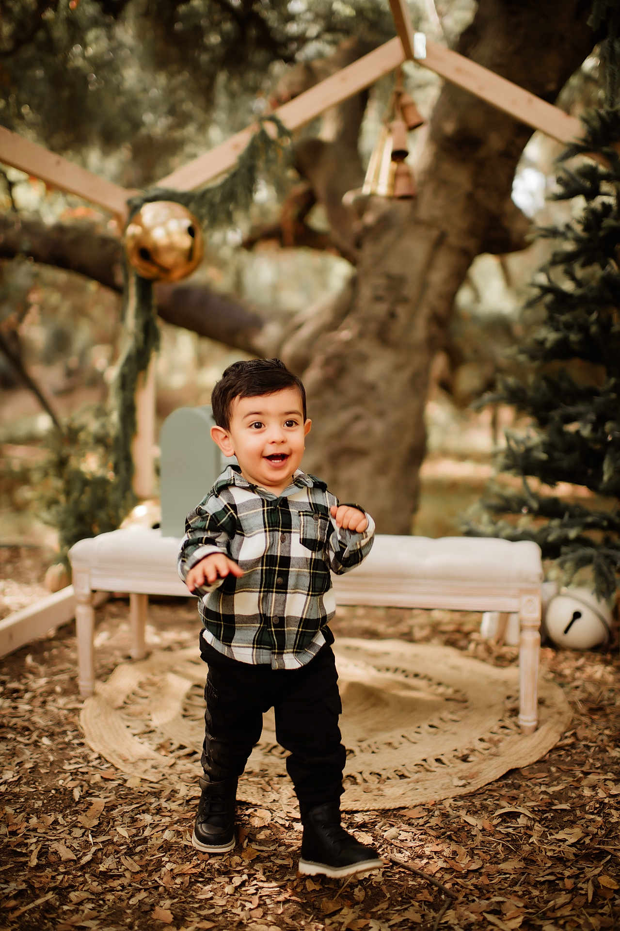 Landon is registered to the contest to win money with this photo: toddler, child, plaid_shirt, black_boots, outdoor, forest, autumn_leaves, bench, decorations, tree, happy, walking, young_child, nature, smiling, person, cute, playful, seasonal, daylight
