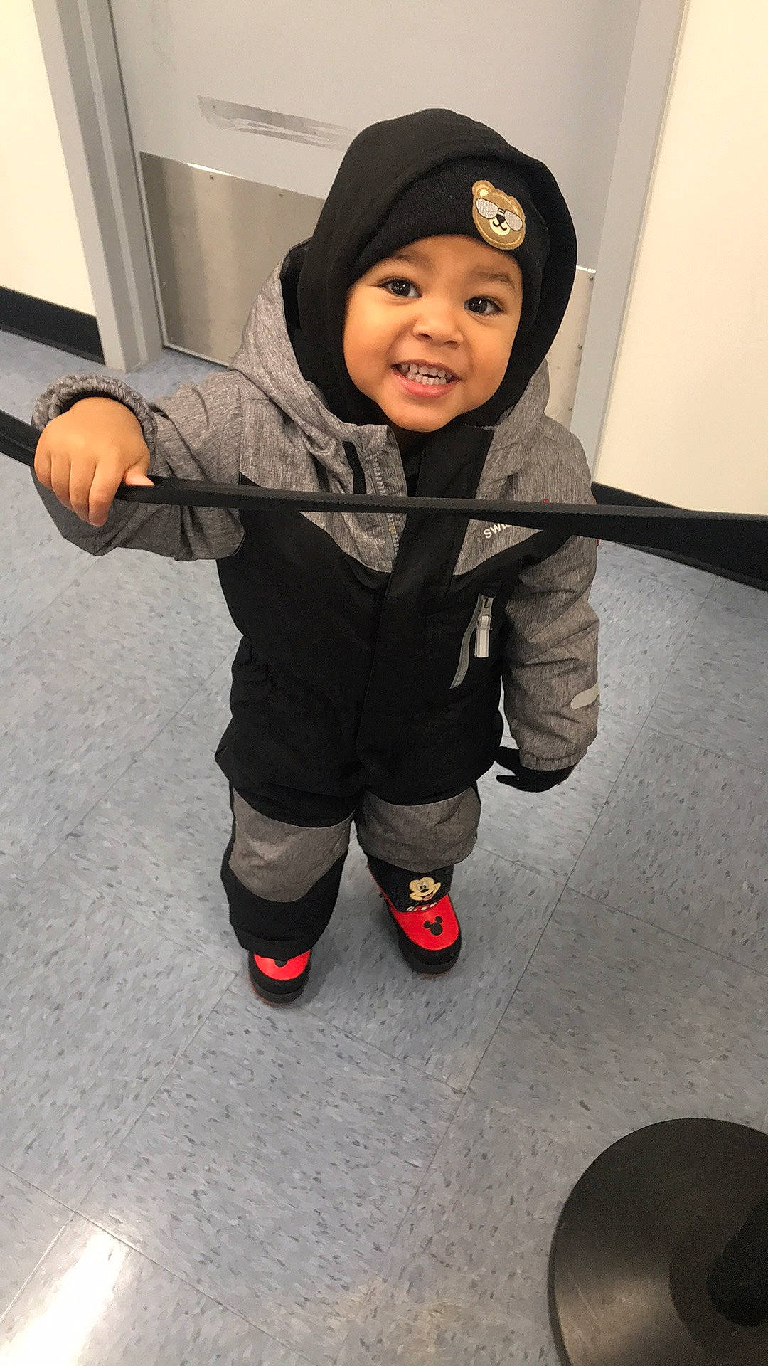 Aceon is registered to the contest to win money with this photo: baby, baby_toddler_clothing, cap, carmine, cheek, child, comfort, flooring, fun, happy, headwear, hoodie, joy, leg, person, personal_protective_equipment, shoe, sitting, sleeve, smile