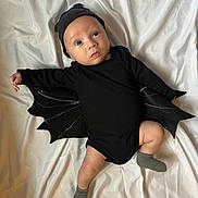 Landry joined the competition — help win amazing prizes! baby, infant, costume, bat_wings, black_clothing, hat, lying_down, white_background, cute, adorable, child, portrait, sock, one_person, indoors, fabric, expression, looking_up, small_child, soft_lighting