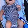 Montgomery is registered to the contest to win money with this photo: baby, infant, smiling, striped_onesie, blanket, sunscreen, lying_down, happy, cute, child, person, skin, foot, hand, face, outdoor, colorful, fabric, relaxing, joyful