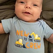 Montgomery joined the competition — help win amazing prizes! baby, infant, smiling, onesie, clothing, blue, text, construction, excavator, blanket, lying_down, cute, face, head, skin, child, young, happy, indoors, person
