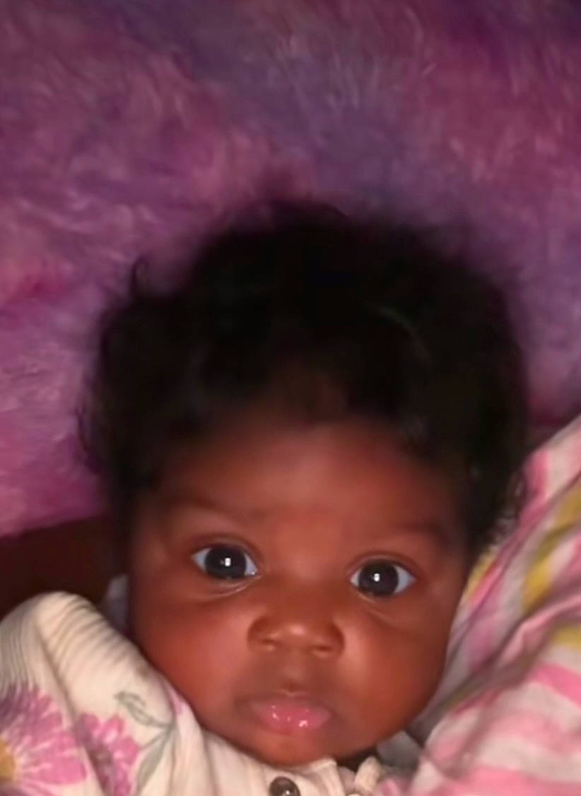 Zyla is registered to the contest to win money with this photo: baby, blanket, child, close-up, cozy, curly_hair, cute, expression, eyes, face, floral_pattern, indoor, infant, person, pink, portrait, purple, skin, soft_texture, young