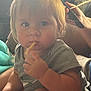 Ty is registered to the contest to win money with this photo: baby, child, snack, hair, hand, face, gray_clothing, indoor, person, eating, combing, hair_clip, closeup, cute, skin, arm, sitting, light, background, candid
