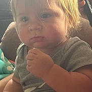 Ty joined the competition — help win amazing prizes! toddler, child, baby, blonde_hair, face, hand, gray_shirt, indoors, soft_light, closeup, portrait, couch, seated, curly_hair, cute, expression, skin, person, young_child, chubby_cheeks