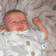 Winston is registered to the contest to win money with this photo: baby, infant, blanket, onesie, clothing, sleeping, bed, soft, cute, newborn, face, portrait, hand, comfort, rest, indoor, child, wear, button, relax