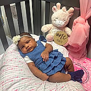 Skylynn is registered to the contest to win money with this photo: baby, infant, crib, pillow, plush_toy, giraffe, dress, headband, sock, girl, nursery, pink, blue, soft_toy, sleepy, child, cute, pattern, fabric, indoor