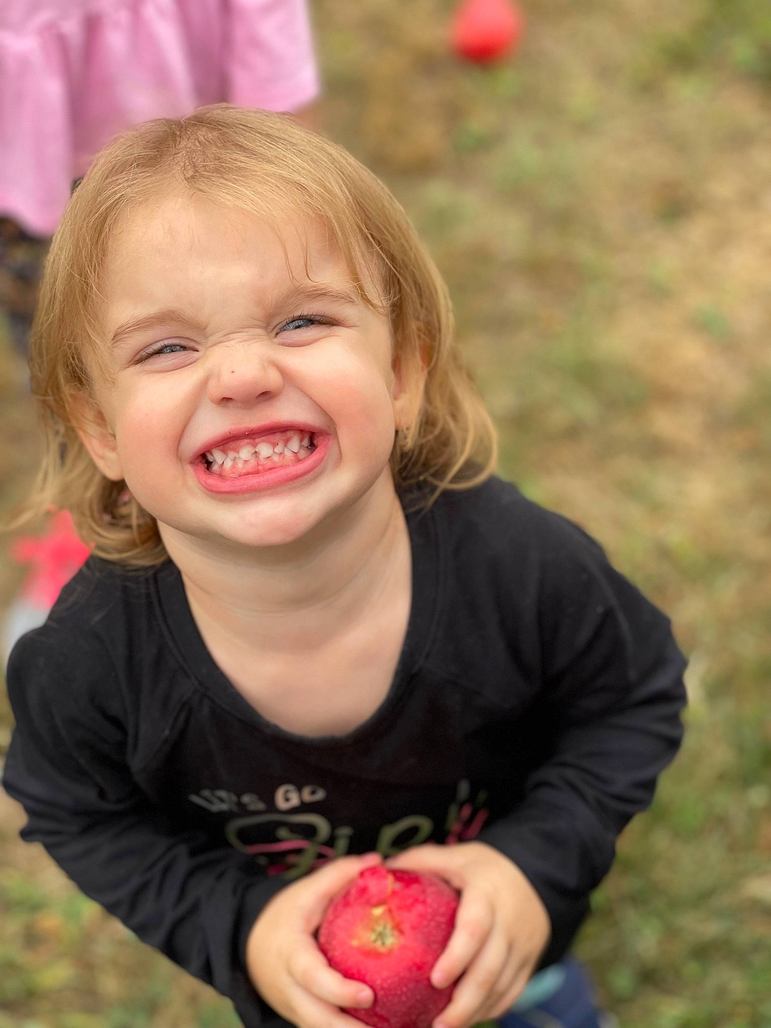 Emery is registered to the contest to win money with this photo: cheek, face, facial_expression, finger, grass, happy, head, iris, joy, lip, mouth, nose, people, people_in_nature, person, pink, plant, red, skin, smile