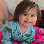 Ever is registered to the contest to win money with this photo: toddler, child, smiling, baby, face, hair, blue_clothing, dinosaur_print, blanket, pink_blanket, happy, indoors, portrait, cute, lying_down, skin, hand, eyes, young_child, cozy