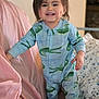 Ever is registered to the contest to win money with this photo: toddler, child, smiling, onesie, crocodile_pattern, dimples, indoor, blanket, bed, bedding, pink_blanket, happy, cute, person, portrait, young_child, clothing, standing, home, cozy