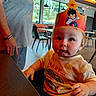 Isaac joined the competition — help win amazing prizes! baby, child, infant, portrait, crown, dragon_ball, anime, wide_eyed, serious_expression, seated, high_chair, toddler, shirt, race_car, restaurant, cafe, indoor, adult, tables, windows