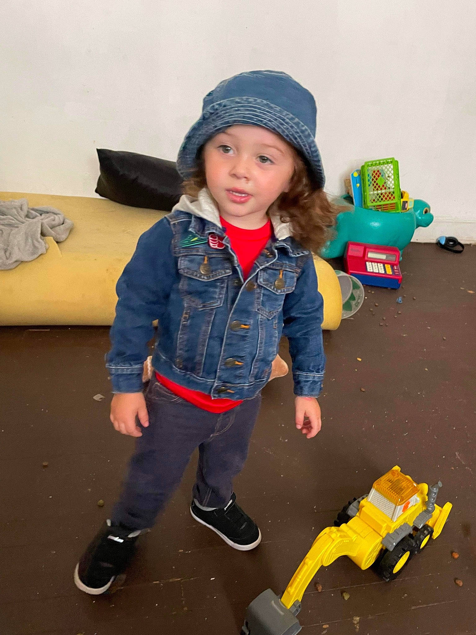Elijah is registered to the contest to win money with this photo: bag, beanie, cap, child, costume, denim, electric_blue, fashion_accessory, flooring, fun, headwear, luggage_and_bags, machine, pattern, person, personal_protective_equipment, play, sitting, toddler, toy