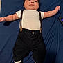 Auriel is registered to the contest to win money with this photo: baby, infant, child, lying_down, white_shirt, black_pants, suspenders, sneakers, blue_blanket, cute, adorable, portrait, indoors, person, footwear, clothing, fashion, young_child, smiling, hair
