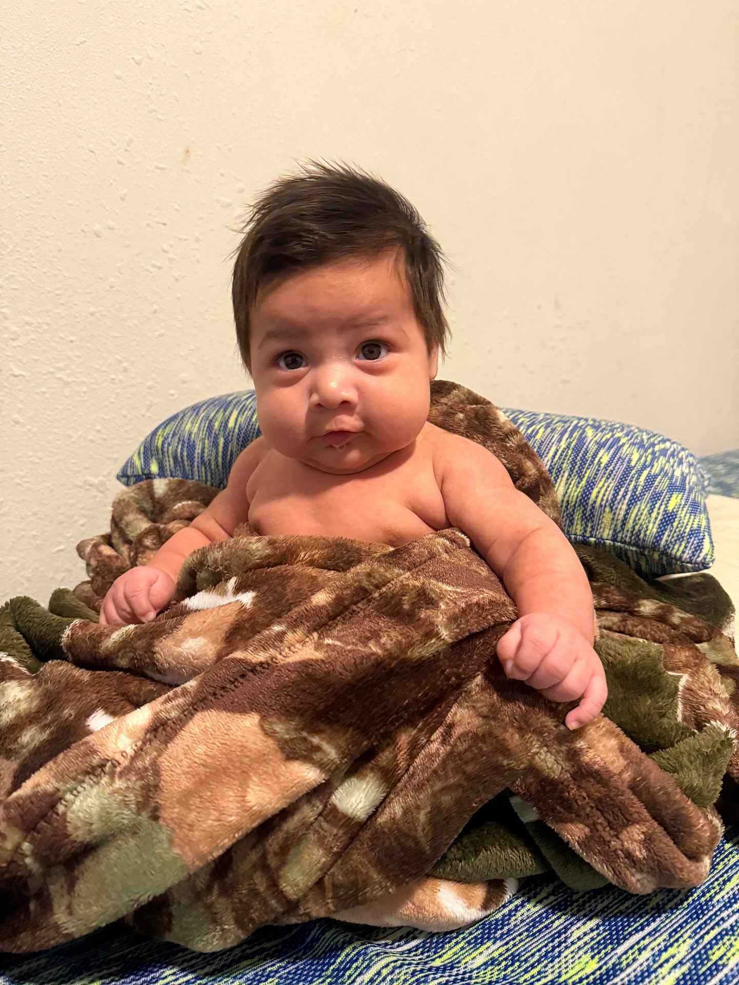 Auriel joined the competition — help win amazing prizes! baby, child, blanket, brown, camo, camouflage, cute, expression, face, indoor, infant, person, plush, portrait, resting, sitting, soft, wall, young, young_child