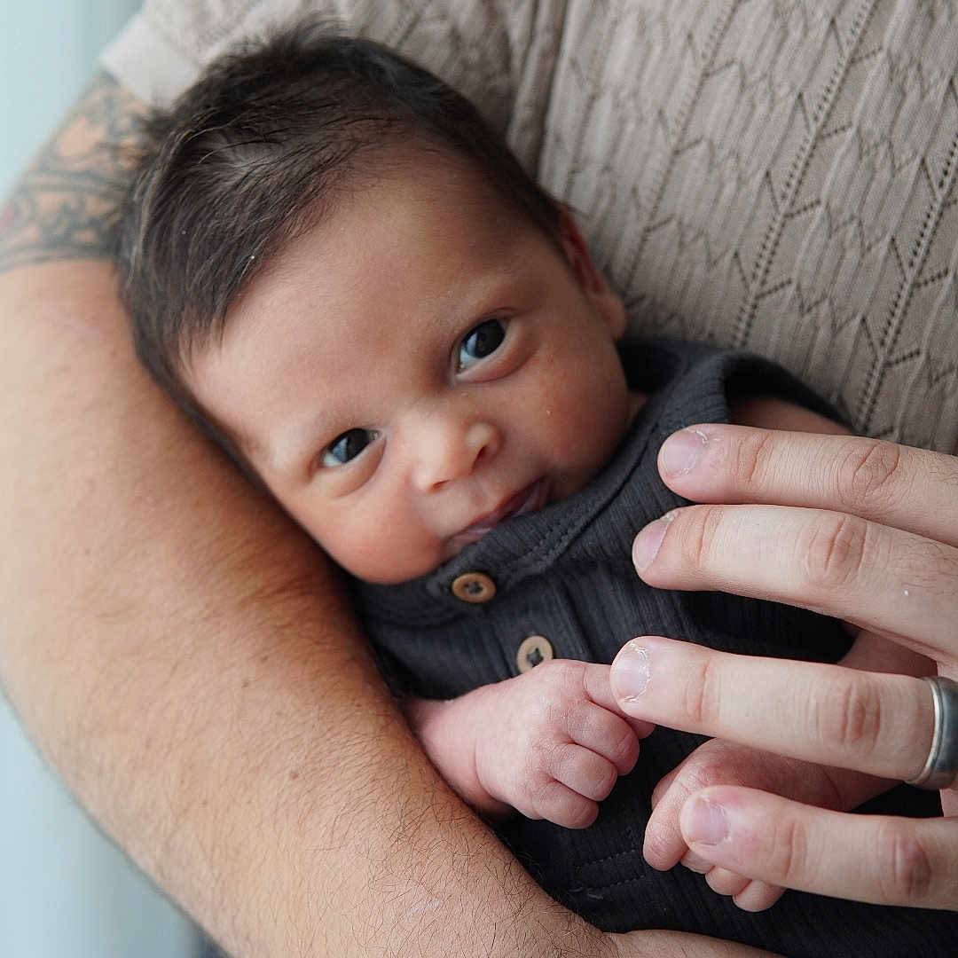 Lucas is registered to the contest to win money with this photo: accessories, baby, bodypart, clothing, face, finger, hand, happy, head, jewelry, knitwear, newborn, person, photography, portrait, ring, skin, smile, sweater, tattoo