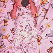Randy is registered to the contest to win money with this photo: baby, infant, pacifier, blanket, winnie_the_pooh, onesie, laying_down, sleepy, milestone, text_overlay, cartoon_characters, cute, child, bedtime, headwear, patterned_clothing, pink, soft, newborn, portrait