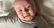 Randy joined the competition — help win amazing prizes! baby, infant, child, blanket, gray_clothing, rocket_design, smiling, lying_down, soft_texture, indoors, portrait, cute, young_child, head, face, human, one_person, baby_garment, relaxed, natural_light