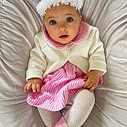 Juliette a rejoint le concours — aidez-le/la à gagner de superbes lots ! baby, child, infant, dress, cardigan, headband, flower, pink, white, striped, tights, socks, cushion, seated, indoors, soft_lighting, cute, portrait, looking_up, hands