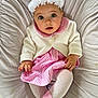 baby, child, infant, dress, cardigan, headband, flower, pink, white, striped, tights, socks, cushion, seated, indoors, soft_lighting, cute, portrait, looking_up, hands