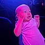 Meadow is registered to the contest to win money with this photo: baby, clothing, cute, dark_background, expression, face, hand, indoor, infant, light, lying_down, newborn, person, pink, portrait, purple, skin, small, soft_light, striped