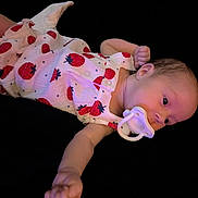 Meadow is registered to the contest to win money with this photo: arm, baby, black_background, child, clothing, cute, expression, face, hand, head, infant, lying_down, newborn, pacifier, portrait, resting, skin, sleepwear, soft_lighting, strawberry_pattern