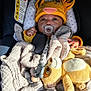 baby, pacifier, car_seat, blanket, plush_toy, hat, yellow, infant, child, cute, warm, soft, cozy, clothing, face, hand, indoors, seat, comfort, sleepy