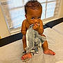 Julien joined the competition — help win amazing prizes! baby, child, infant, plush_toy, pacifier, medical_table, window, curtains, indoor, person, skin, sitting, cute, looking_up, expression, soft_toy, hand, foot, blanket, light