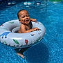 baby, pool, inflatable_ring, water, smiling, child, summer, outdoor, sunlight, blue, floating, swimming_pool, happy, vacation, cute, fun, playful, person, leisure, relaxation