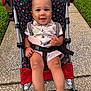 baby, stroller, child, smiling, outdoor, grass, sidewalk, clothing, bow_tie, suspenders, cute, happy, person, footwear, pattern, mickey_mouse, seat_belt, wheels, skin, face