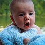 baby, blue_blanket, face, infant, outdoor, water, nature, trees, expression, skin, eyes, mouth, hand, portrait, candid, child, young, soft_texture, closeup, serene