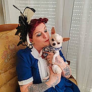 Cleo participe au concours pour gagner de l'argent avec cette photo : woman, dog, chihuahua, tattoos, vintage_chair, blue_dress, red_hair, makeup, face, pet, holding, indoor, curtains, window_blind, patterned_clothing, small_dog, seated, love, portrait, fashion