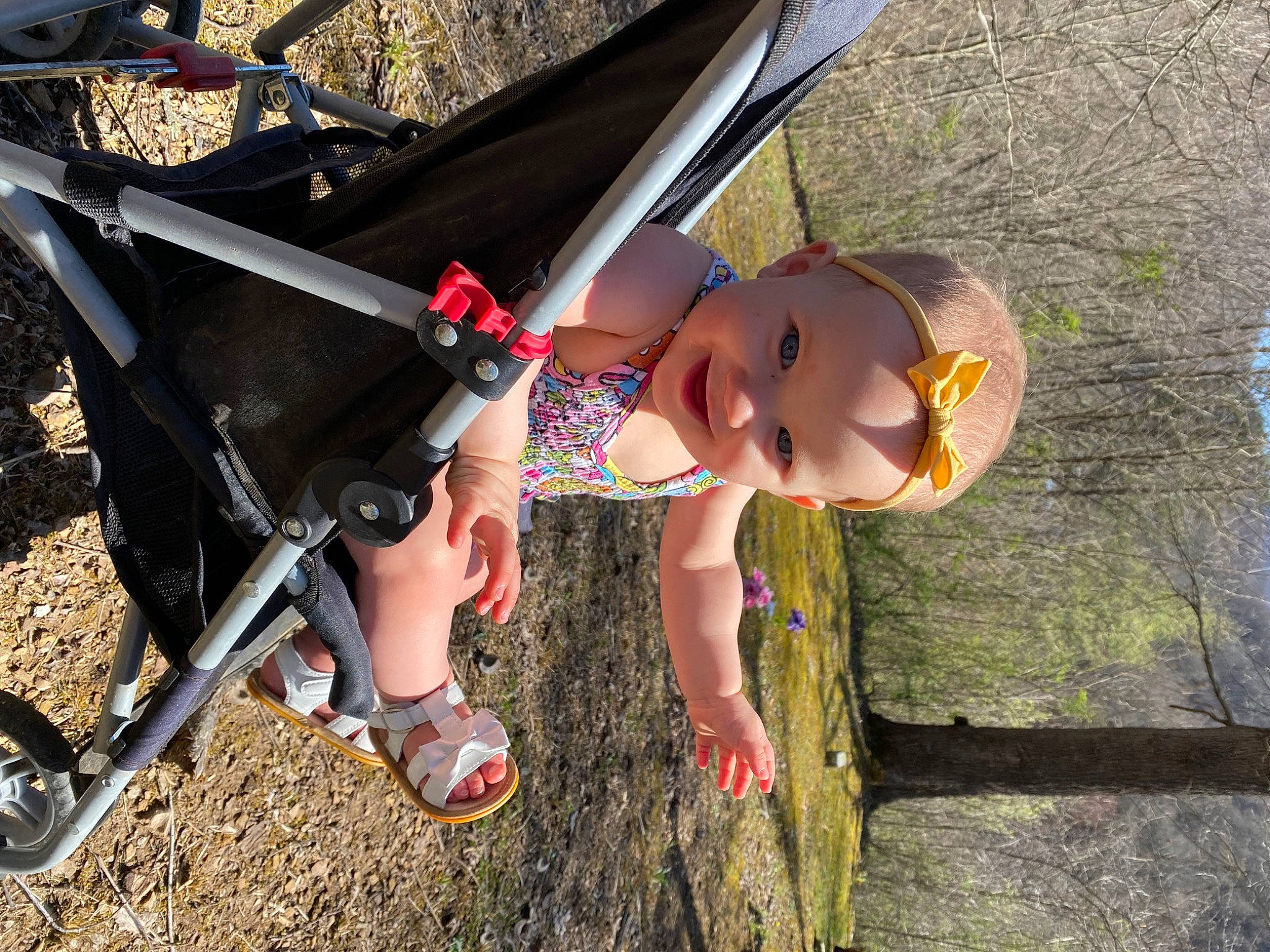 Kyla is registered to the contest to win money with this photo: adventure, auto_part, automotive_exterior, baby_carriage, bicycle_frame, bicycle_tire, bicycles_equipment_and_supplies, grass, hat, joy, landscape, leg, leisure, person, personal_protective_equipment, recreation, smile, tire, toddler, tree