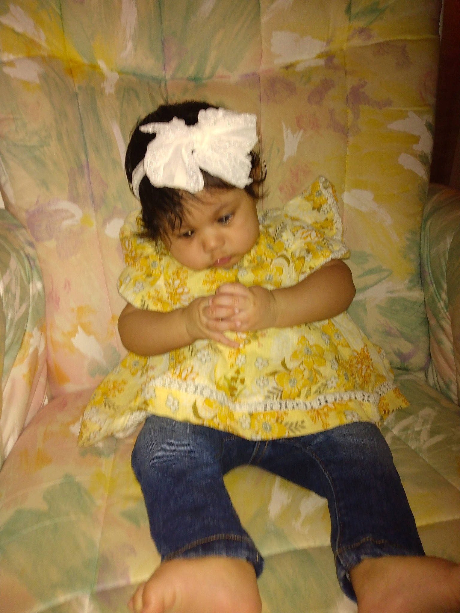 Paulina is registered to the contest to win money with this photo: baby, baby_toddler_clothing, cheek, child, comfort, embellishment, foot, fun, happy, headband, headpiece, headwear, human_leg, lap, linens, pattern, person, petal, room, sitting