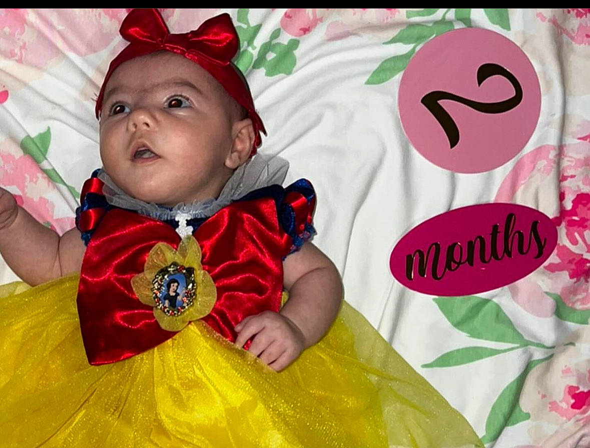 Leilani is registered to the contest to win money with this photo: baby, baby_toddler_clothing, cap, child, event, fashion_accessory, fun, grass, happy, headwear, leisure, magenta, person, pink, play, portrait_photography, recreation, sleeve, sweetness, t_shirt