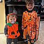 baby, celebration, child, children, clothing, costume, cute, face_paint, floor, girl, halloween, holding_hands, holiday, indoor, jack_o_lantern, portrait, pumpkin, shoes, smiling, toddler