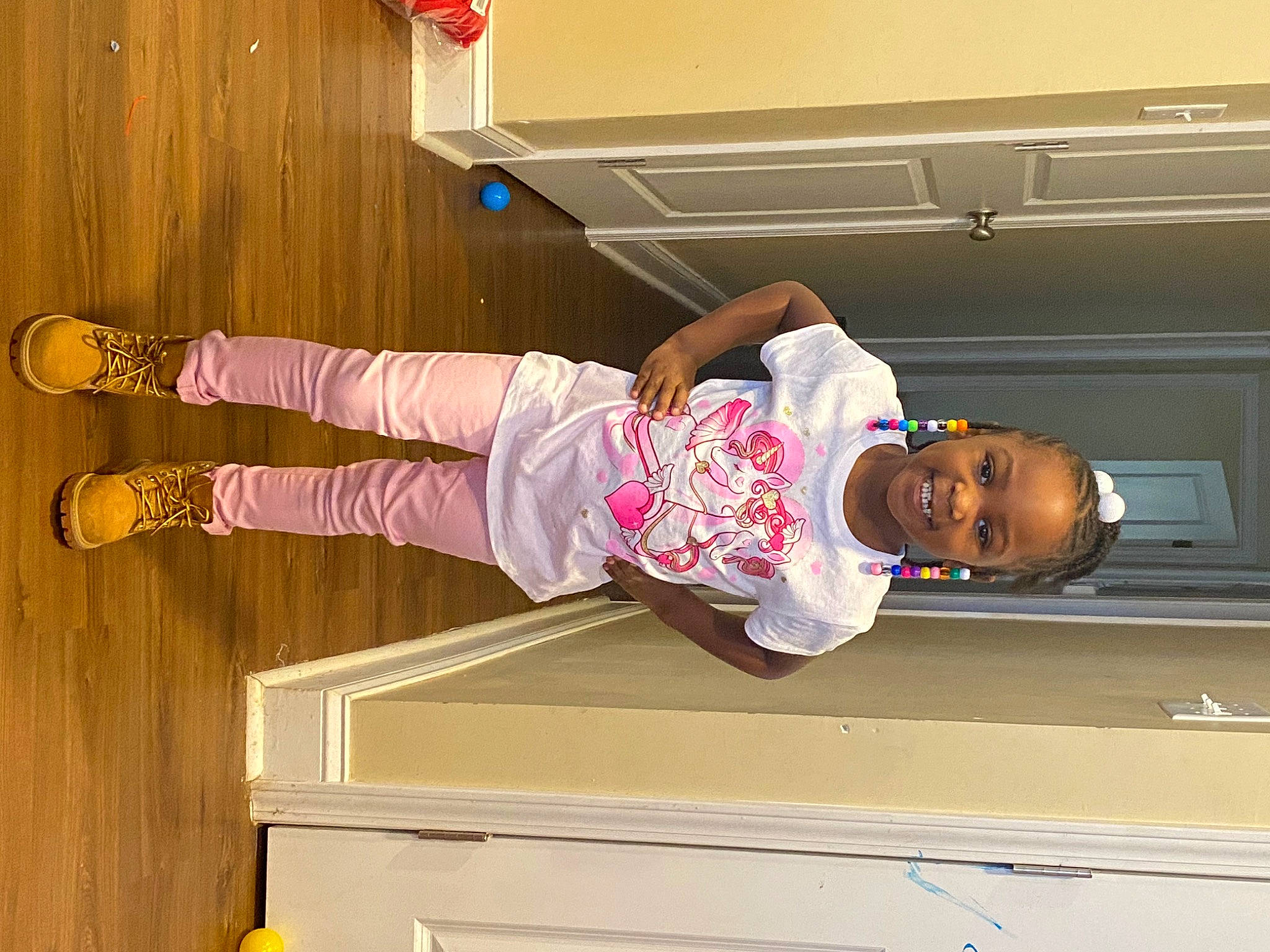 Khalaya is registered to the contest to win money with this photo: baby_toddler_clothing, child, flooring, fun, happy, hardwood, hat, joy, outdoor_shoe, person, room, smile, sock, toddler, walking_shoe, wood, yellow