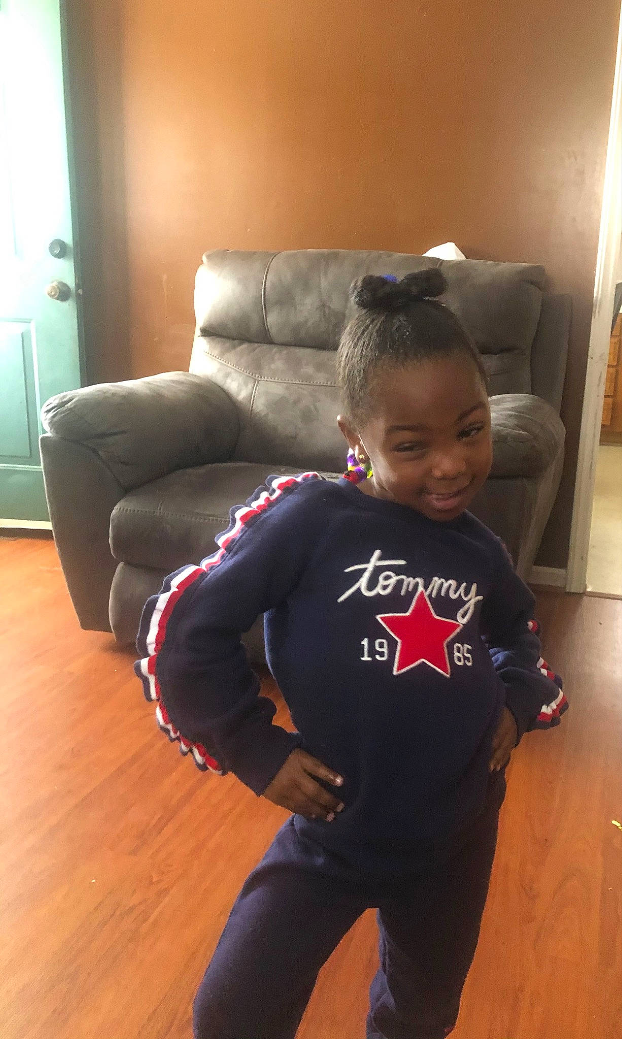 Khalaya is registered to the contest to win money with this photo: active_pants, baby_toddler_clothing, comfort, couch, floor, flooring, hardwood, human_leg, joy, knee, laminate_flooring, living_room, neck, person, sleeve, sweatpant, t_shirt, thigh, toddler, trunk