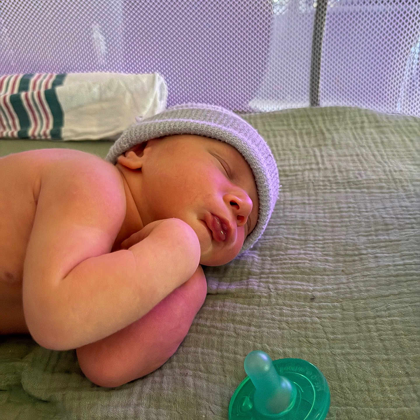 Ryker is registered to the contest to win money with this photo: newborn, baby, infant, sleeping, portrait, hat, knit_hat, pacifier, blanket, quilt, bed, lying_down, curled_up, closed_eyes, peaceful, indoor, soft_lighting, nursery, adorable, photography