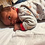 baby, infant, lying_down, bed, onesie, teddy_bear_print, soft_fabric, cute, curious, sleepwear, child, skin, hand, face, head, indoors, newborn, portrait, resting, cozy