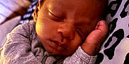 Xavier joined the competition — help win amazing prizes! baby, child, closeup, cozy, cute, face, grey_clothing, hand, indoors, infant, leopard_print, newborn, peaceful, pillow, portrait, resting, sleeping, soft_lighting, toddler, wooden_floor