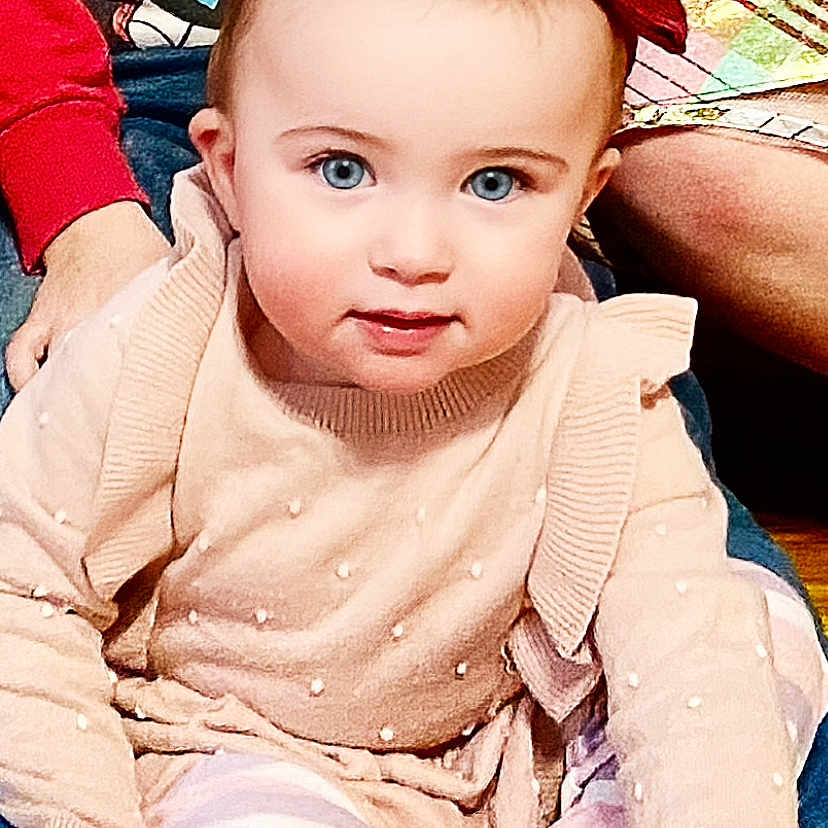 Ella joined the competition — help win amazing prizes! baby, bodypart, clothing, couch, face, finger, furniture, hand, hat, head, knitwear, longsleeve, pants, person, photography, portrait, sitting, sleeve, sweater, toy
