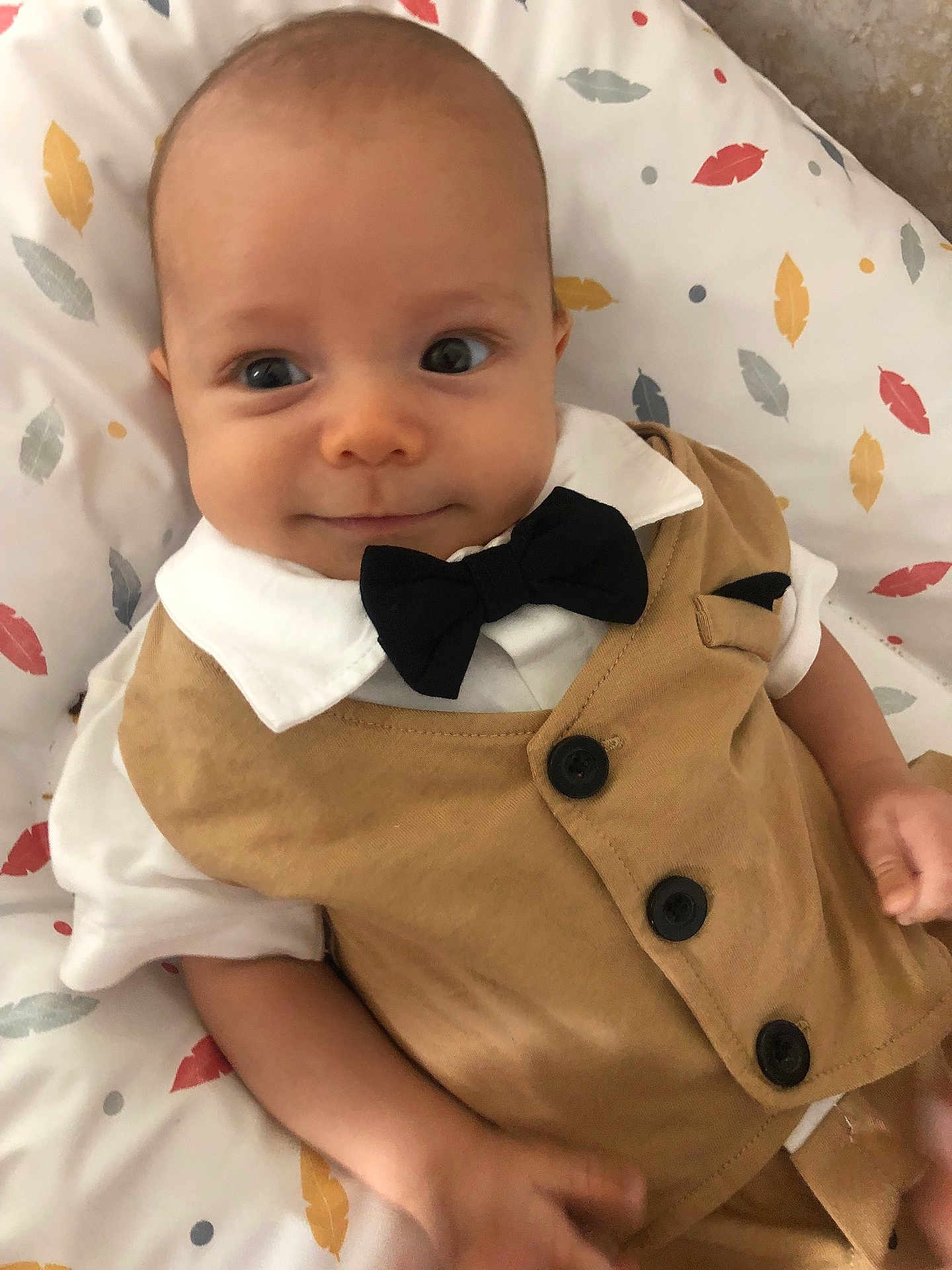 Neylann participe au concours pour gagner de l'argent avec cette photo : baby, infant, child, face, eyes, clothing, vest, bow_tie, white_shirt, blanket, pattern, leaf_pattern, cute, smile, portrait, indoors, skin, head, hand, person