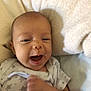 baby, infant, smile, happy, onesie, star_pattern, blanket, soft, fist, lying_down, cute, face, head, skin, person, indoors, cozy, child, newborn, expression