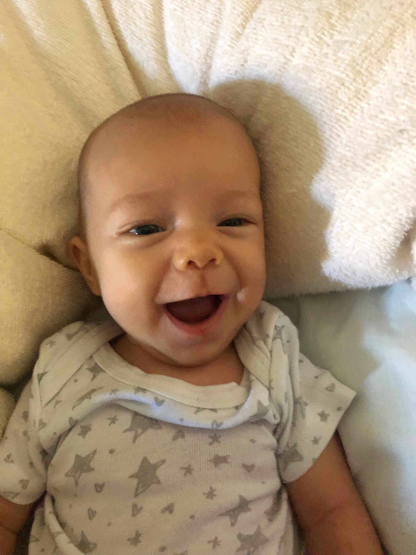 Neylann participe au concours pour gagner de l'argent avec cette photo : baby, smiling, infant, onesie, stars, hearts, blanket, soft, happy, face, cute, child, portrait, lying_down, closeup, skin, expression, baby_clothing, indoor, newborn
