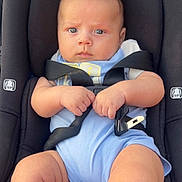 Aaron joined the competition — help win amazing prizes! baby, car_seat, seatbelt, infant, child, blue_clothing, hands, legs, face, safety, straps, serious_expression, indoors, transportation, person, cute, young, closeup, skin, head