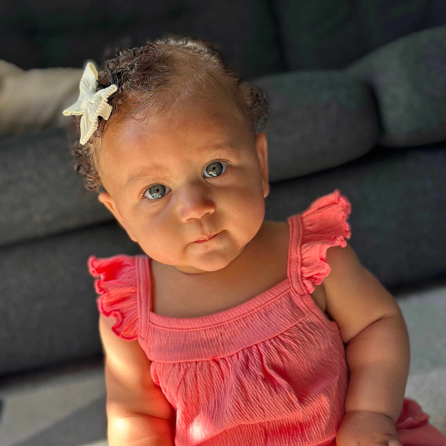 Ariana joined the competition — help win amazing prizes! baby, blue_eyes, child, closeup, couch, curly_hair, cute, expression, face, hand, indoors, infant, person, pink_dress, portrait, sitting, skin, soft_light, starfish_hair_clip, young